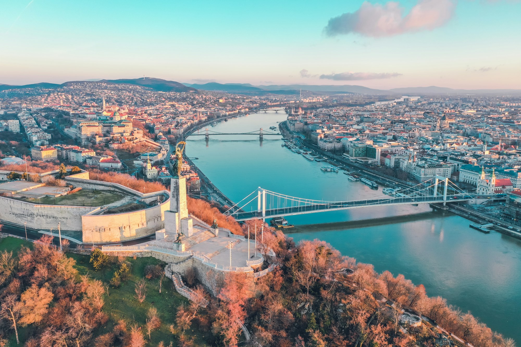 Aerial view of Budapest: the Liberty Statue on Gellért Hill above the Danube at sunrise